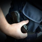 Policjant trzyma rękę na kaburze, w której jest broń