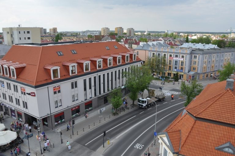 Ulica w centrum miasta, po obu stronach drogi kamienice