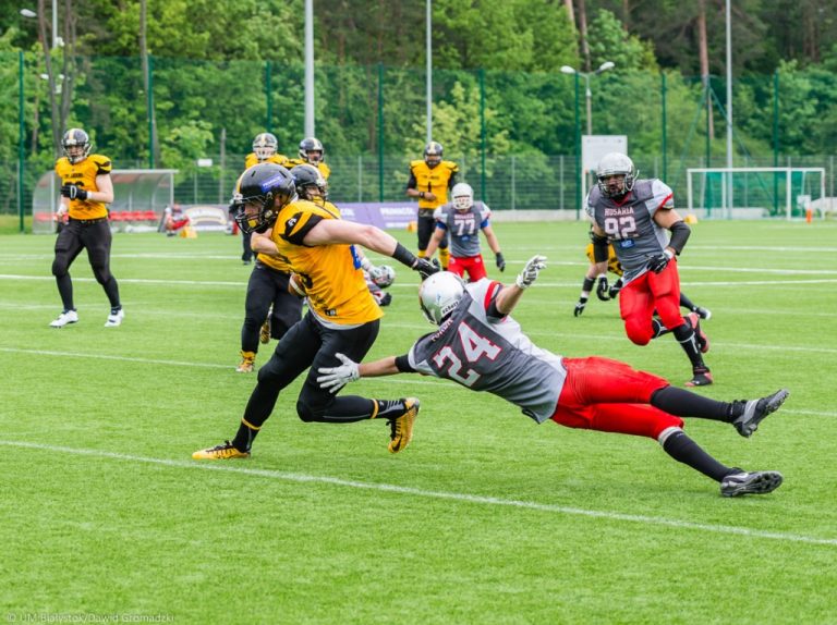 Zawodnicy futbolu amerykańskiego biegają po murawie stadionu