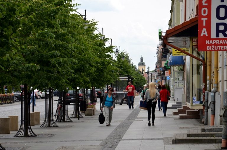 Ulicą w centrum miasta idą ludzie.
