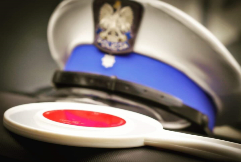 czapka policyjna i lizak policyjny leżą na biurku