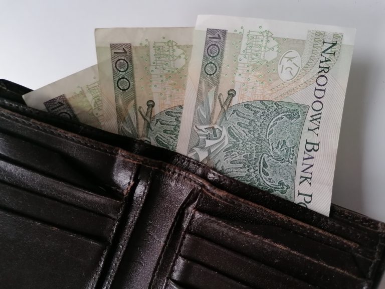 Trzy stuzłotowe banknoty wystają z portfela