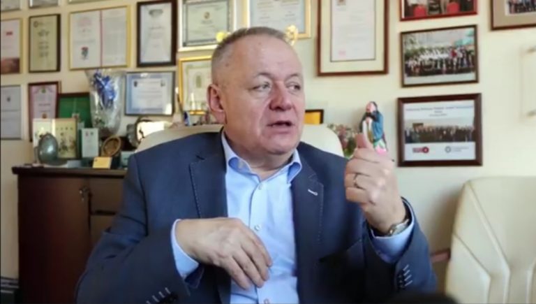 Mężczyzna siedzi za biurkiem w gabinecie