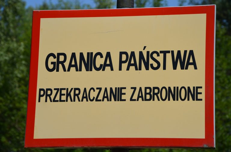 Żółta tabliczka z napisem granica państwa przekraczanie zabronione