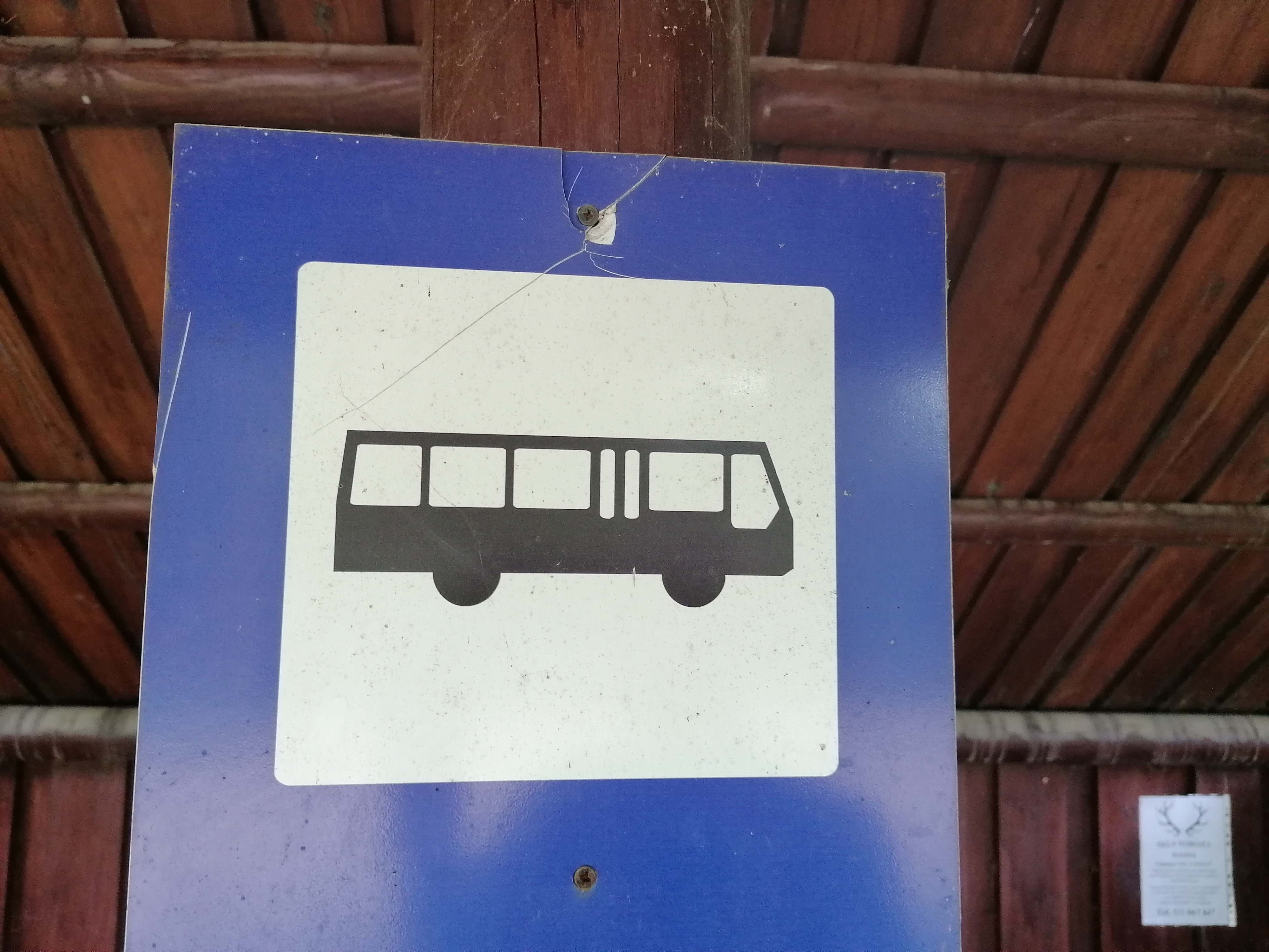 Znak: na niebieskim kwadracie, znajduje się mniejszy, biały kwadrat, na którym jest czarny autobus. Znak oznacza przystanek autobudowy