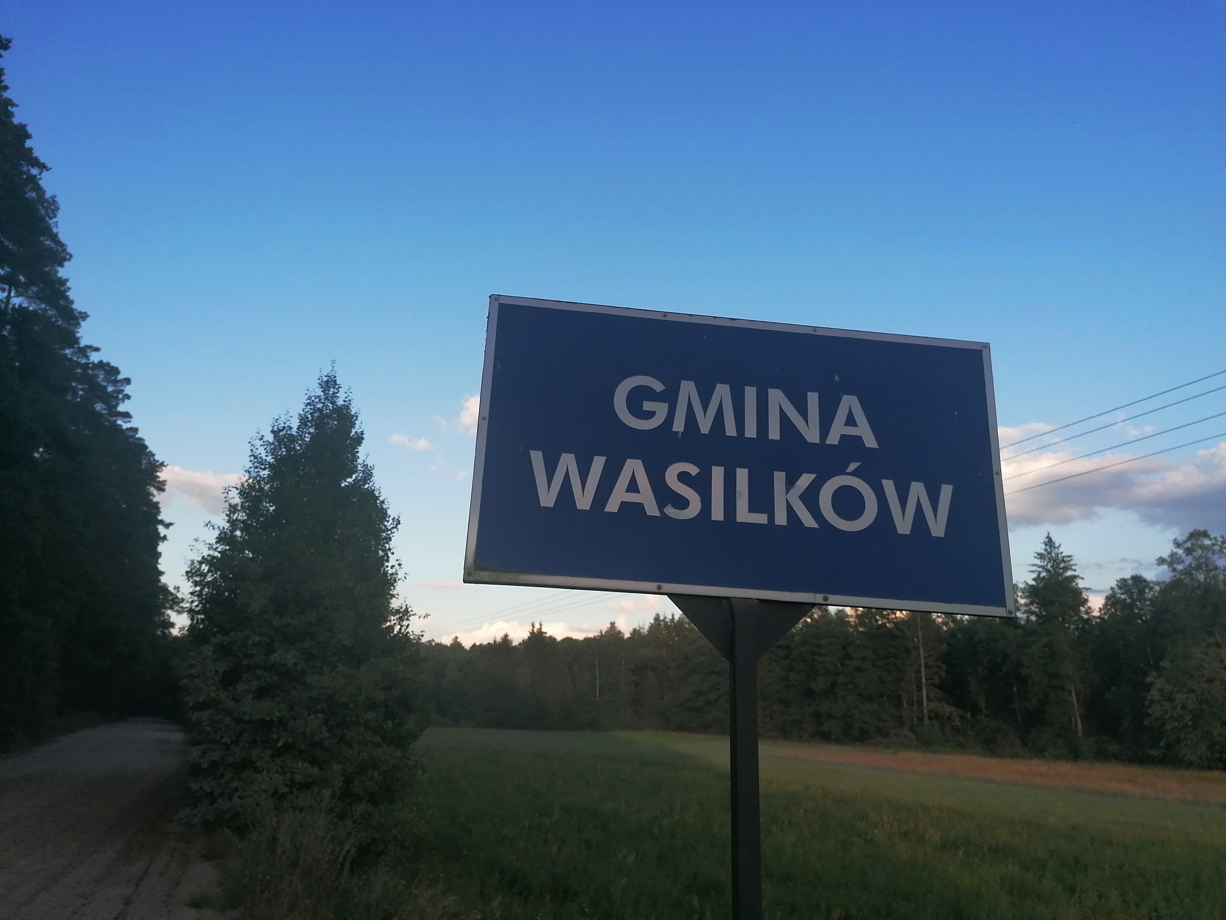 Tablica przy polnej drodze z napisem Gmina Wasilków