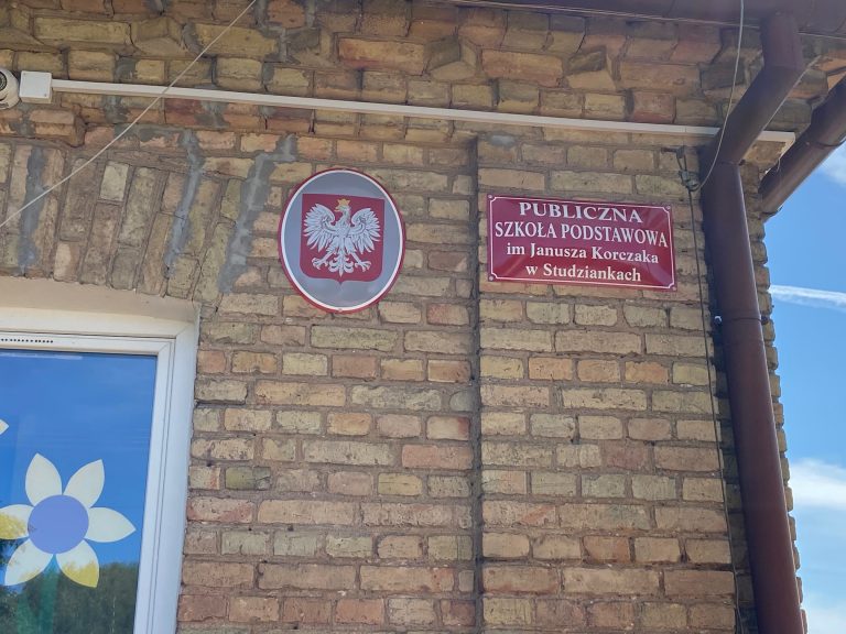 Tabliczka z nazwą szkoły na ścianie budynku