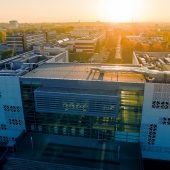 Budynek Centrum Nowoczesnego Kształcenia Politechniki Białostockiej widziany z lotu ptaka na tle zachodzącego słońca