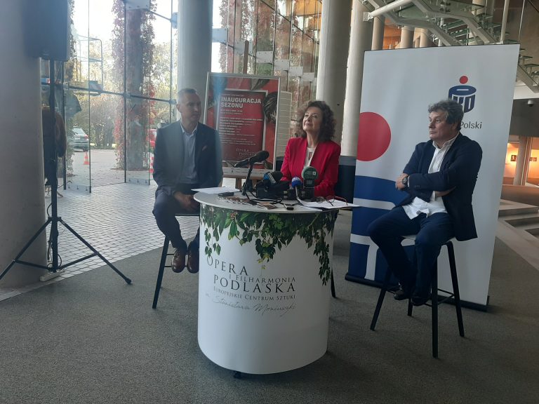 W foyer Opery i Filharmonii Podlaskiej jest ustawiony okrągły stolik przy którym siedzą trzy osoby. Są to m.in. dyrektor Opery prof. Ewa Iżykowska - Lipińska oraz maestro Jacek Błaszczak. Osoby te opowiadają o wydarzeniach zaplanowanych w ramach nowego sezonu artystycznego