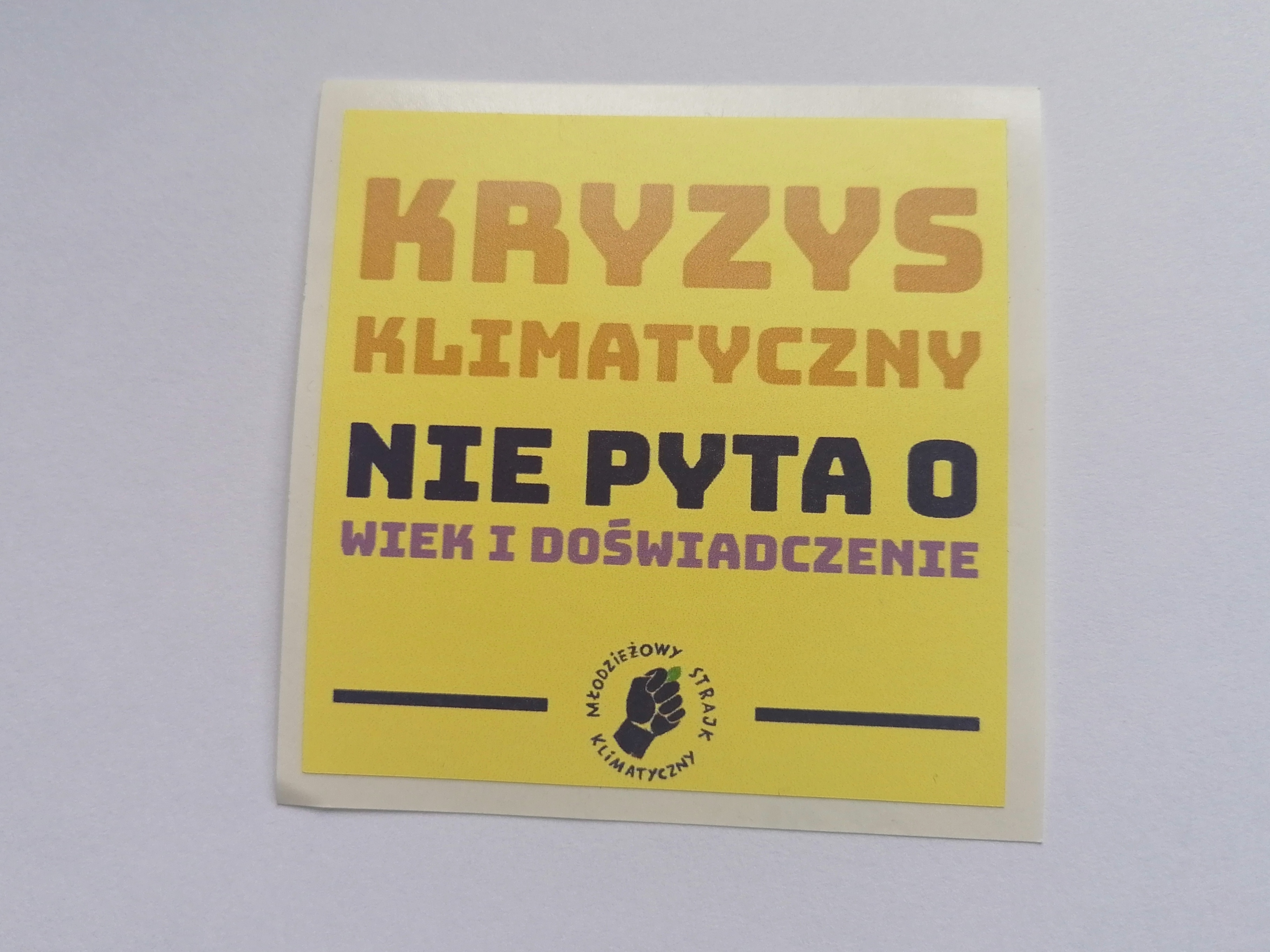 Naklejka z napisem "Kryzys klimatyczny nie pyta o wiek i doświadczenie"