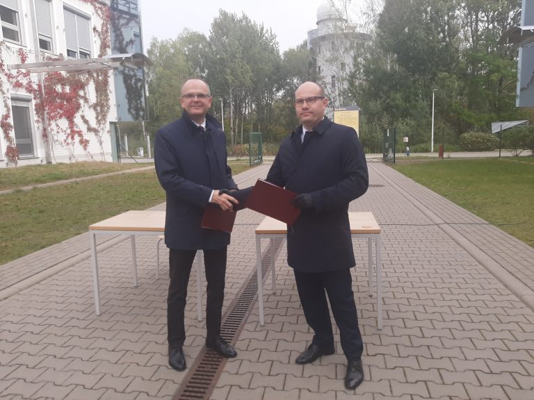 Rektor Uniwersytetu w Białymstoku i marszałek województwa podlaskiego wymieniają się podpisanymi umowami na dofinansowanie wyposażenia obserwatorium. Za nimi widoczna jest kopuła obserwatorium z planetarium