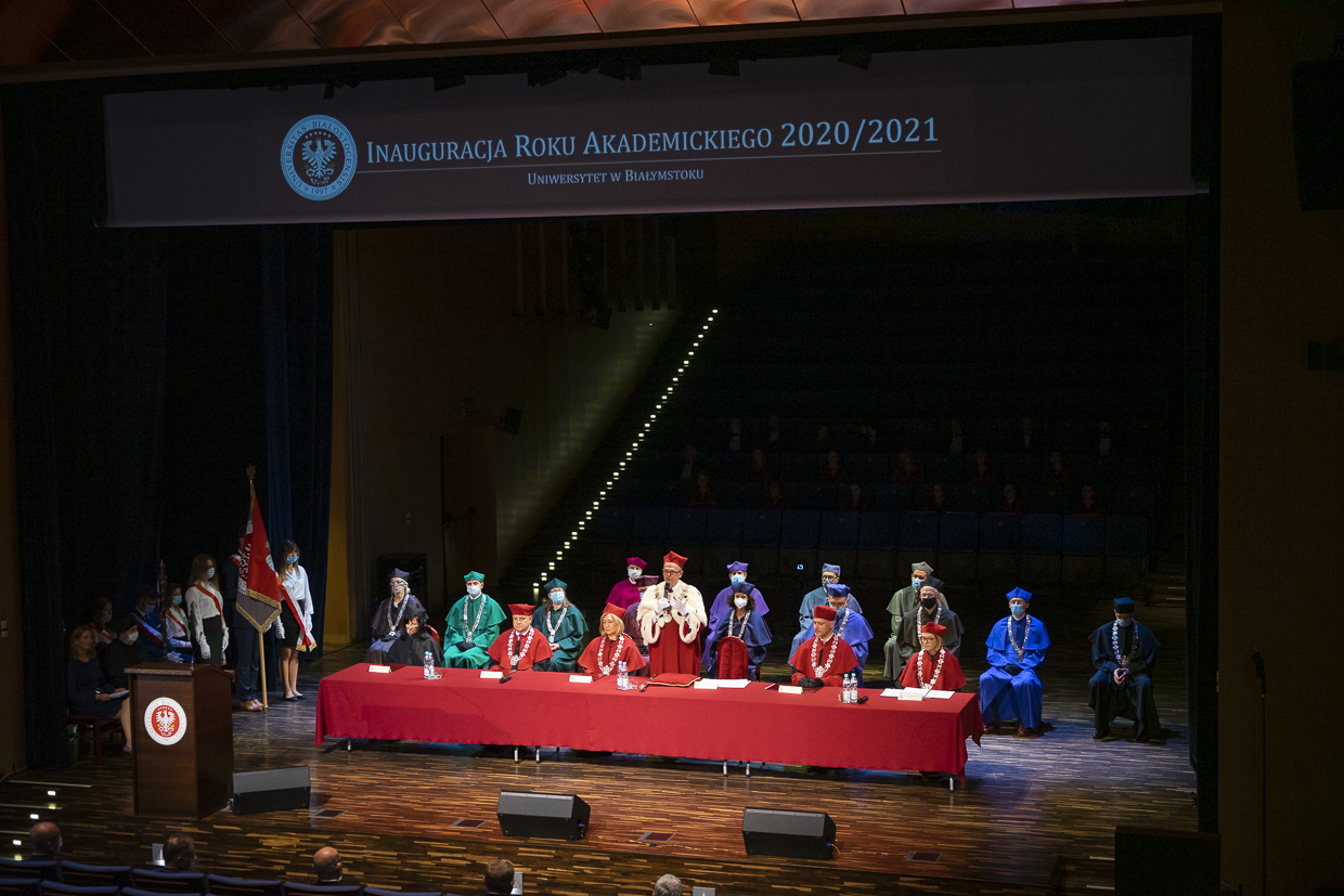 Inauguracja nowego roku akademickiego na białostockim uniwersytecie. Przy stole zasłanym czerwonym obusem stoją członkowie senatu uczelni.
