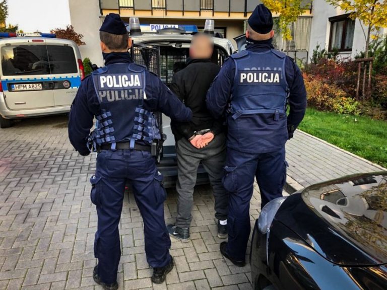 Dwaj policjanci trzymają skutego mężczyznę.