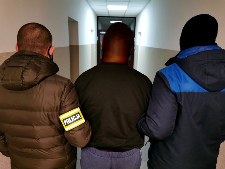 Policjanci trzymają skutego kajdankami mężczyznę