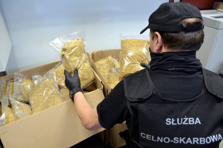 Funkcjonariusz KAS trzyma w ręku torebkę z krajanką tytoniową