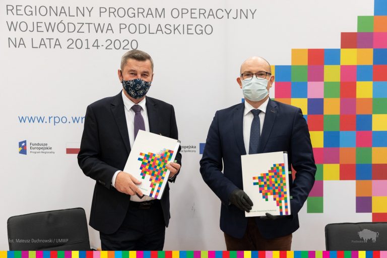 Marszałek i prezes firmy trzymają w rękach umowę na dofinansowanie inwestycji ze środków UE