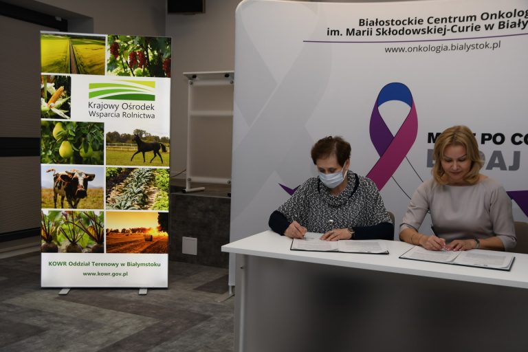 Dwie kobiety przy stole podpisują umowę o współpracy