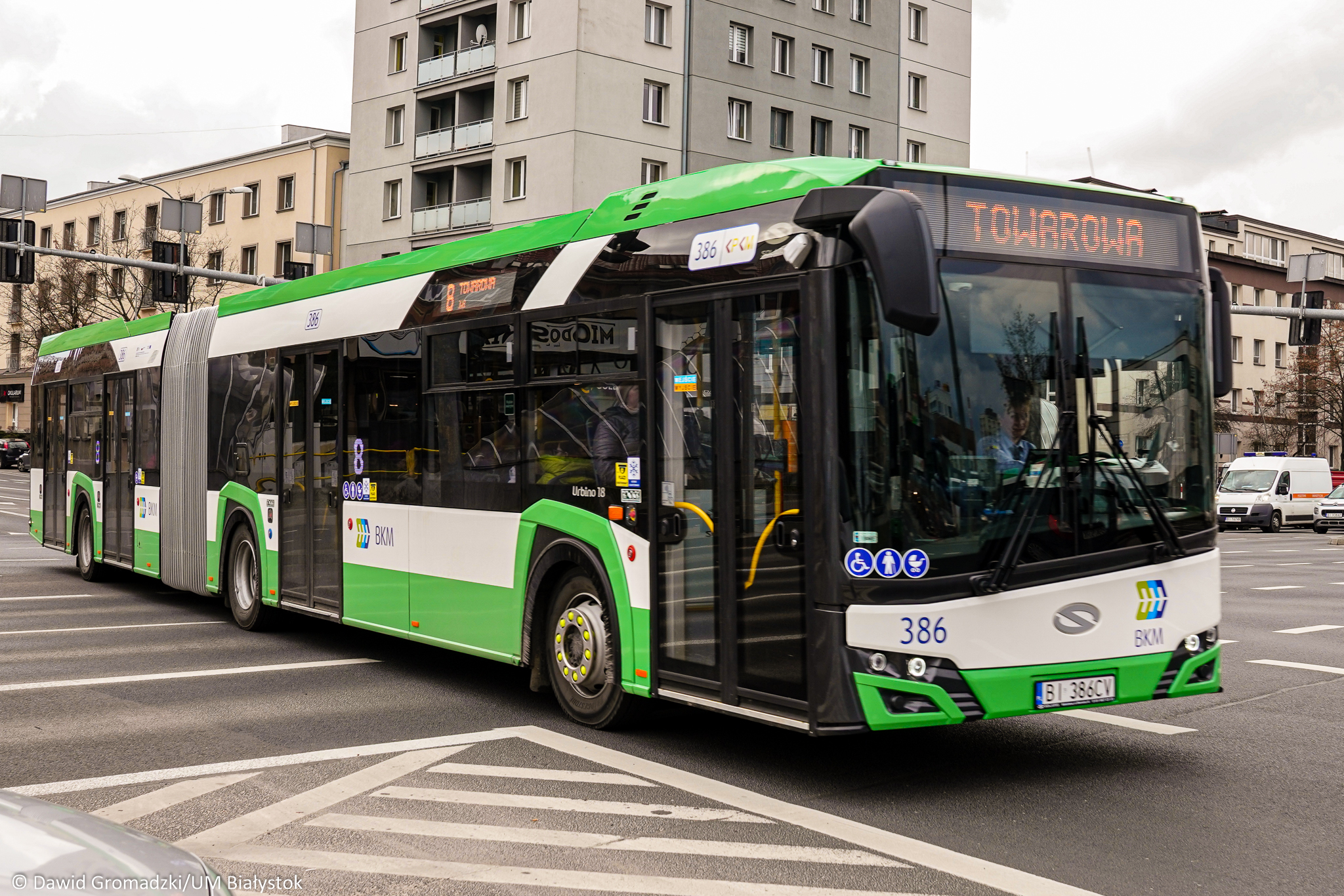 Zielono - czarny autobus miejski przejeżdża przez skrzyżowania Al. Piłsudskiego i Sienkiewicza
