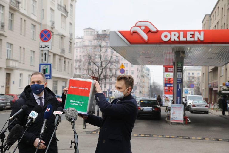 Dwaj posłowie stoją przed stacją paliw