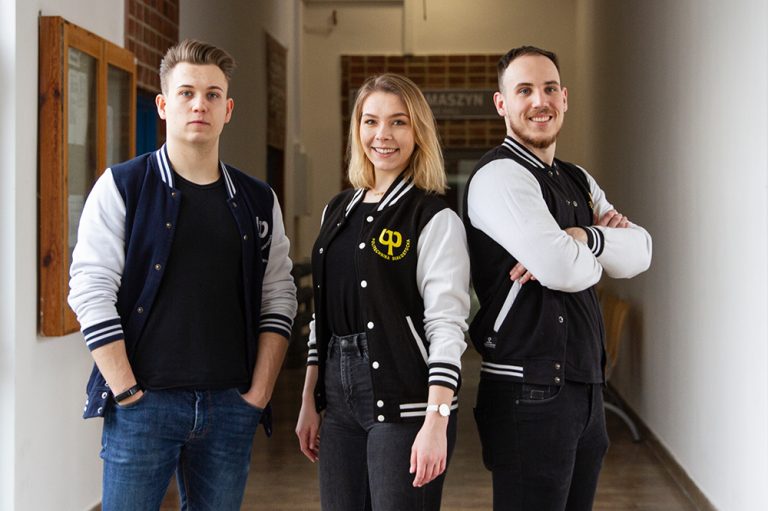 Studenci PB stoją w bluzach z logo uczelni