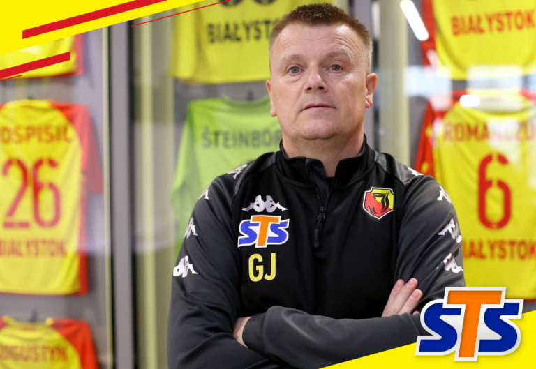 Gerard Juszczak stoi na tle ściany z koszulkami zawodników Jagiellonii