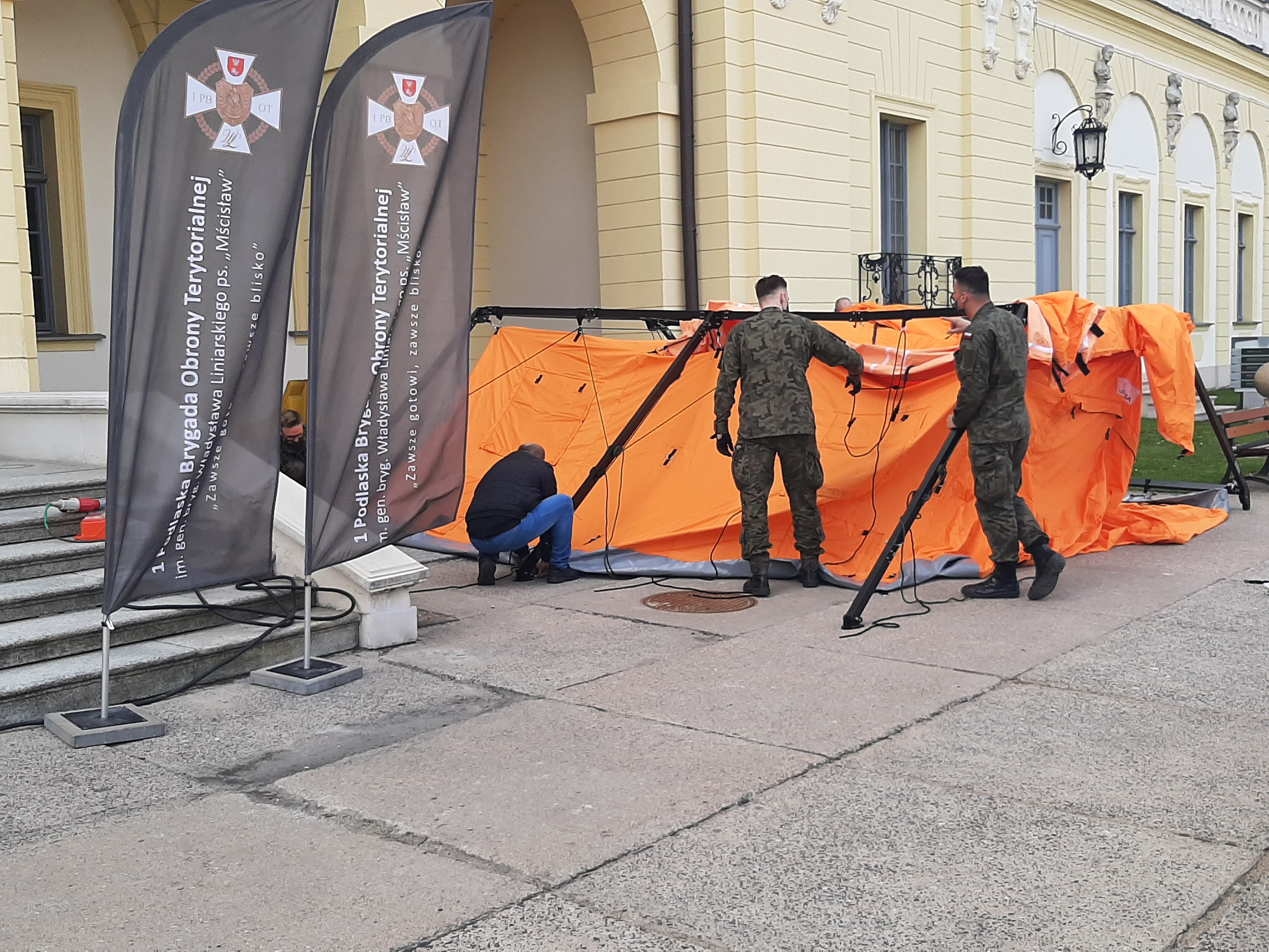 Na dziedzińcu Pałacu Branickich żołnierze rozstawią pomarańczowy namiot. Z lewej strony stoją flagi Wojsk Obrony Terytorialnej