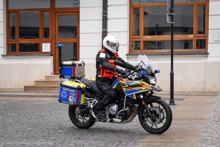 Człowiek w kasku i w specjalnym motocyklowym kombinezonie siedzi na motocyklu