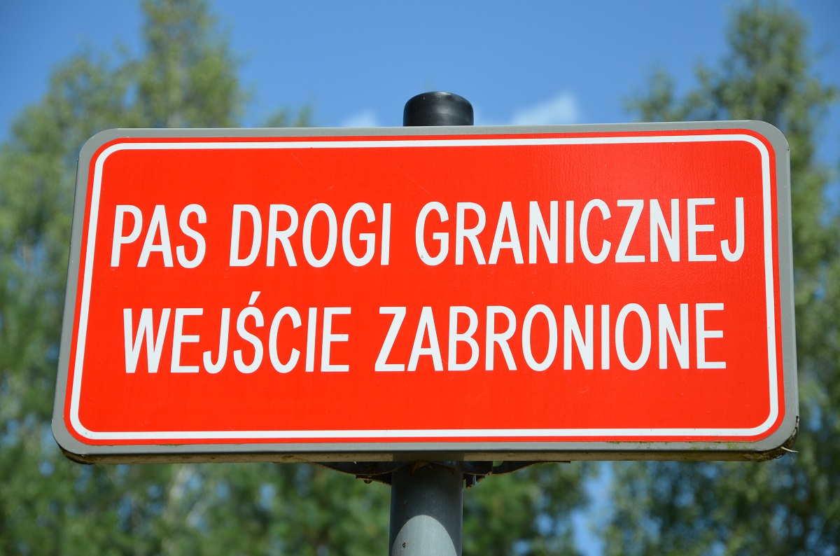 Czerwona tablica z białym napisem pas drogi granicznej wejście zabronione