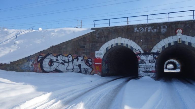 Tunel drogowy w odsłonie zimowej. Na murach widoczne jest graffiti