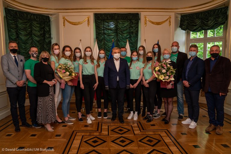 Drużyna siatkarek stoi w rzędzie, przed nimi jest prezydent Białegostoku