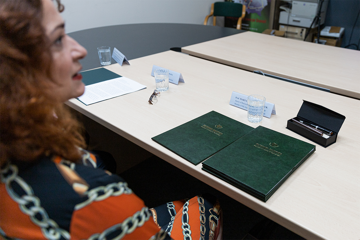 Rektor Politechniki Białostockiej siedzi przy biurku przed podpisaniem umowy