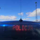 Nieoznakowany radiowóz policji, na tylnej szybie wyświetla się czerwony napis POLICJA