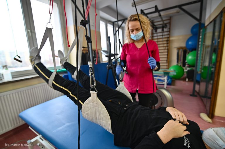 Rehabilitantka pomaga ćwiczyć mężczyźnie