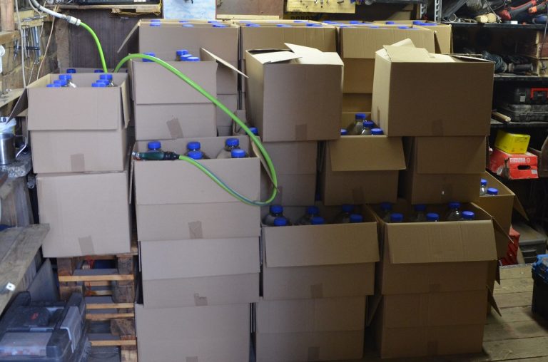 Plastikowe butelki z nielegalnym alkoholem w kartonowych pudłach