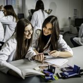 Studentki siedzą przy biurku w laboratorium