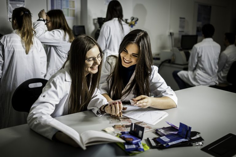 Studentki siedzą przy biurku w laboratorium