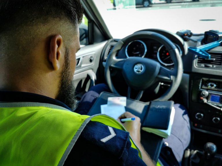 Policjant wypisuje mandat kierowcy