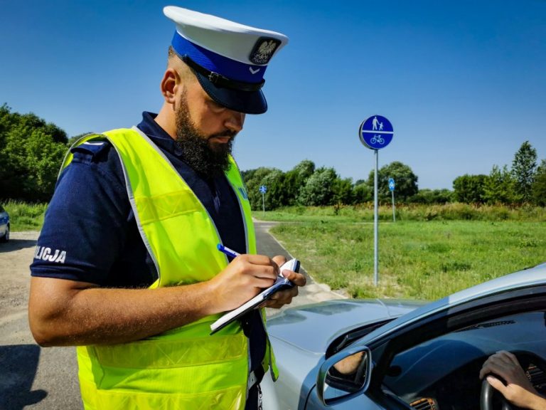Policjant wypisuje mandat karny