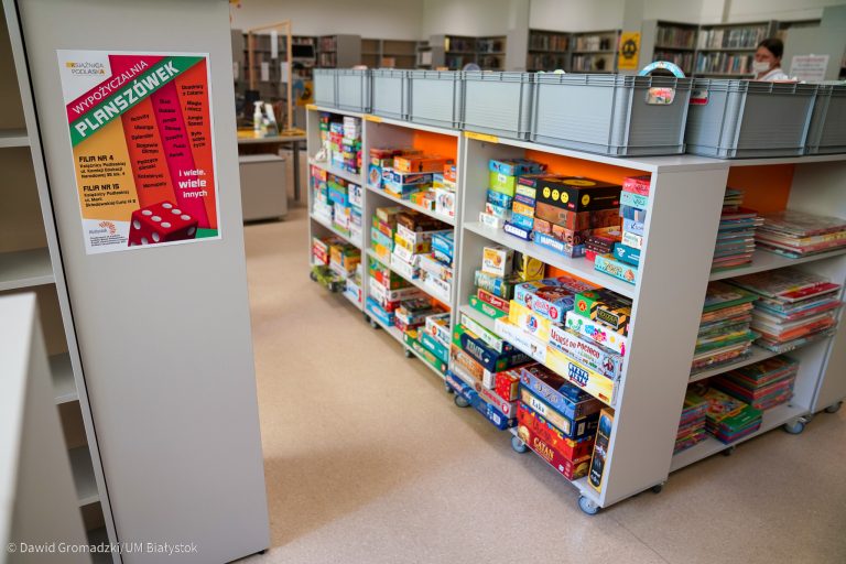 Regał na półkach, którego leżą gry planszowe