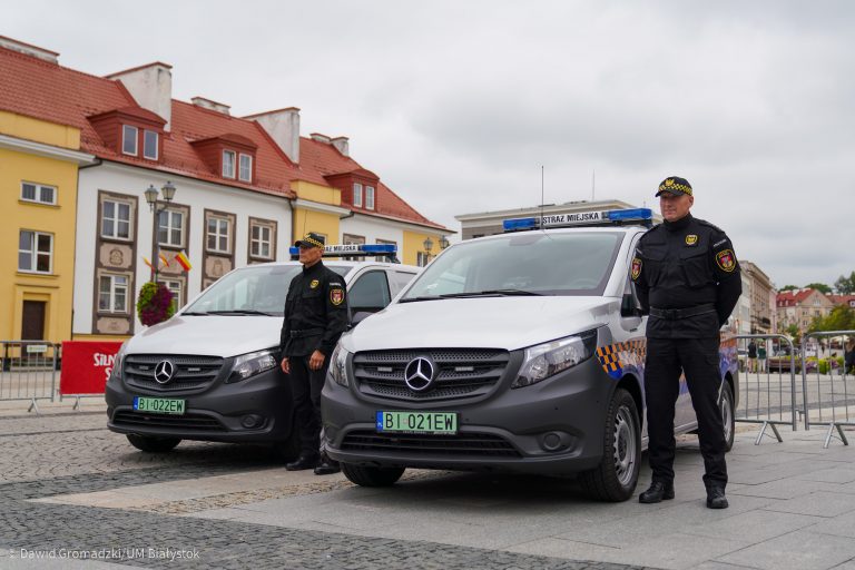 Dwaj strażnicy miejscy stoją przy nowych pojazdach elektrycznych