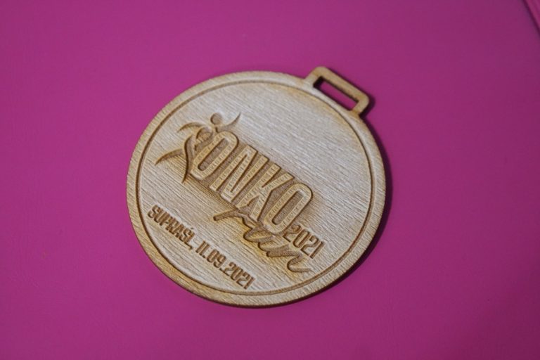 Na różowym tle leży medal, na którym jest wygrawerowany OnkoRun 2021