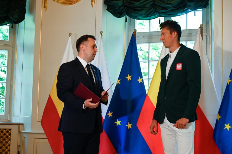 Prezydent wręcza list gratulacyjny zawodnikowi Damianowi Czykierowi