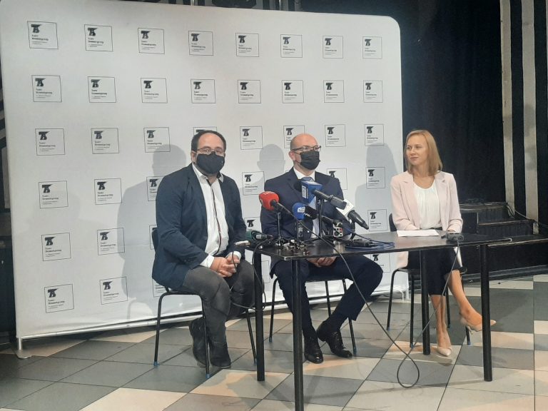 Na ściance Teatru Dramatycznego, przy stoliku siedzą trzy osoby; od lewej strony dyrektor instytucji, po środku marszałek, z prawej zastępczyni dyrektora Teatru Dramatycznego. Przed mówiącymi stoją mikrofony redakcji