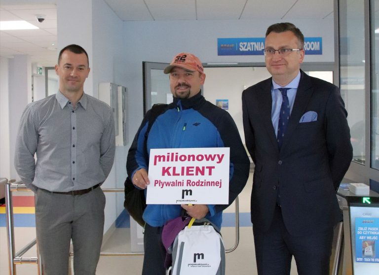 Trzech mężczyzn stoi przed wejściem na pływalnię