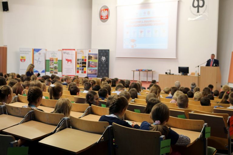 Dzieci siedzą w uczelnianej auli