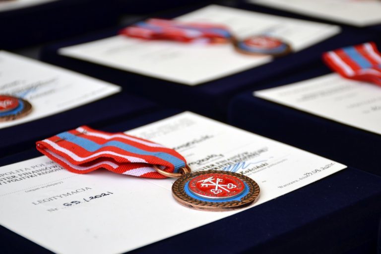 Medale i odznaczenia wraz z dokumentami leżą na stole.