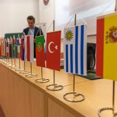 Na sbiurku stoją proporczyki, z flagami różnych krajów