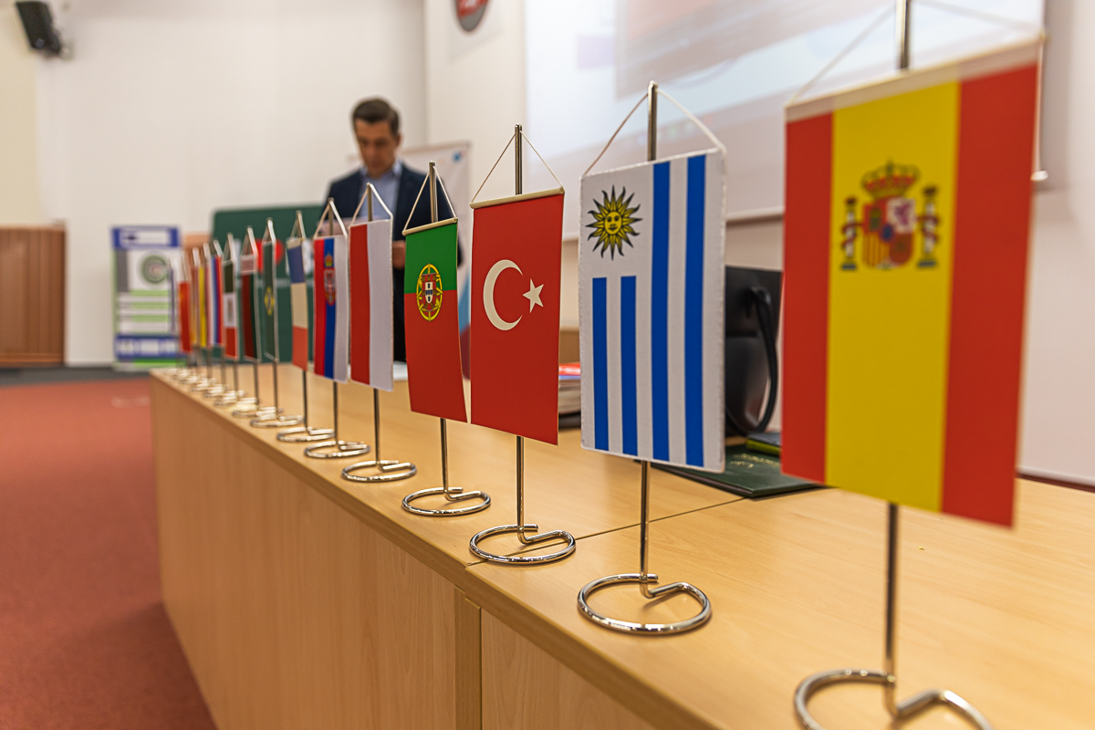Na sbiurku stoją proporczyki, z flagami różnych krajów