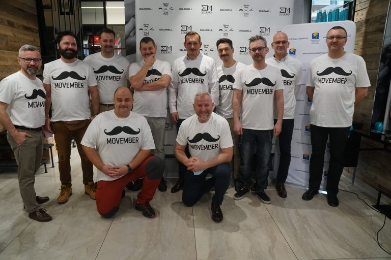 Grupa mężczyzn w białych koszulkach, na których namalowano wąsy i napisano Movember