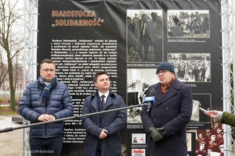 Trzej mężczyźni mówią do mikrofonu